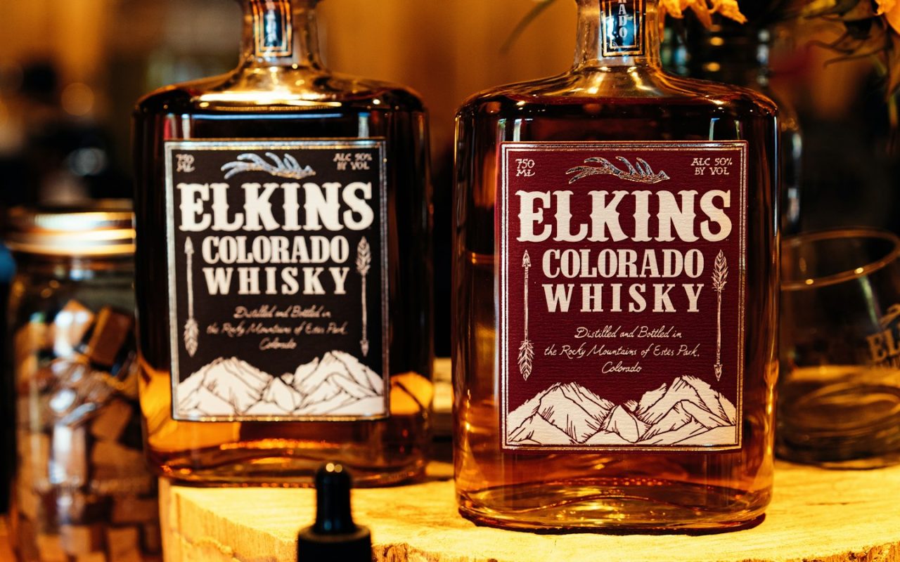 Selection of premium glass bottled craft drinks lined up on a wooden bar counter